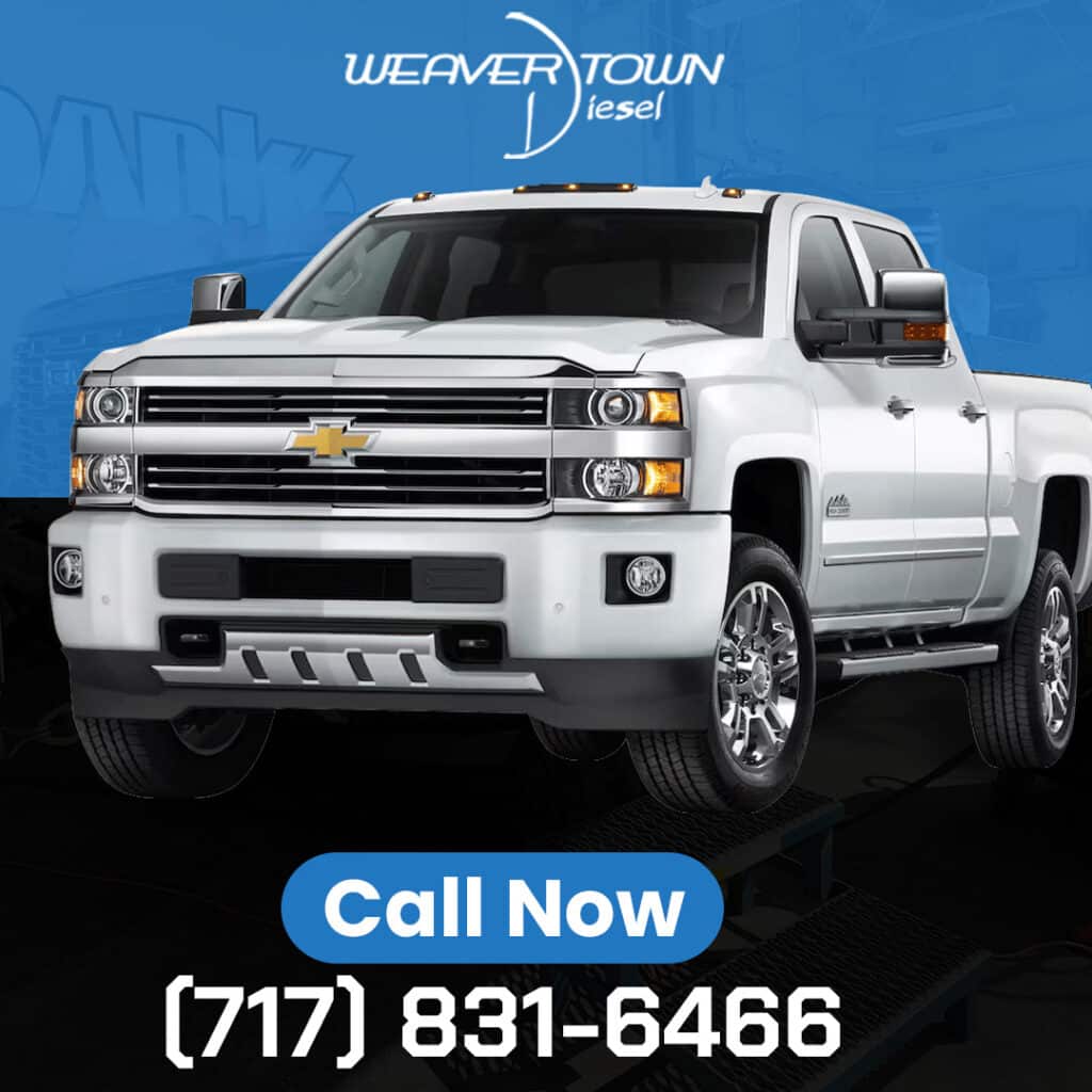 A white Chevrolet Silverado HD pickup truck on a service lift with Weavertown Diesel branding and contact information.